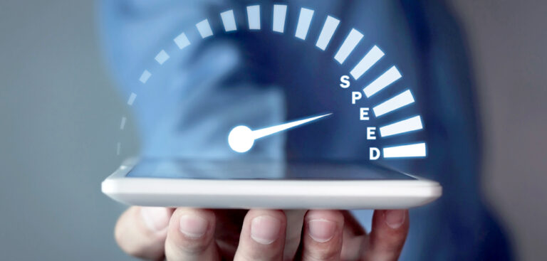 Mano sosteniendo un smartphone con un velocímetro digital indicando alta velocidad