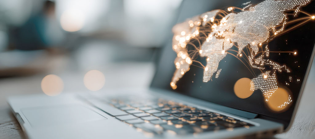 Portátil mostrando un mapa mundial iluminado con conexiones digitales